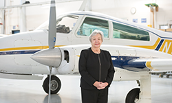 Pat Reese in front of an airplane at the aviation hangar on the PCC Rock Creek Campus.